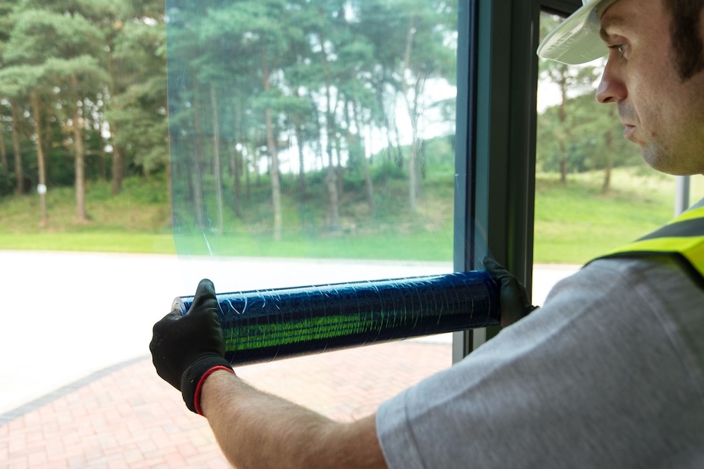Blue window protection film being applied to a window